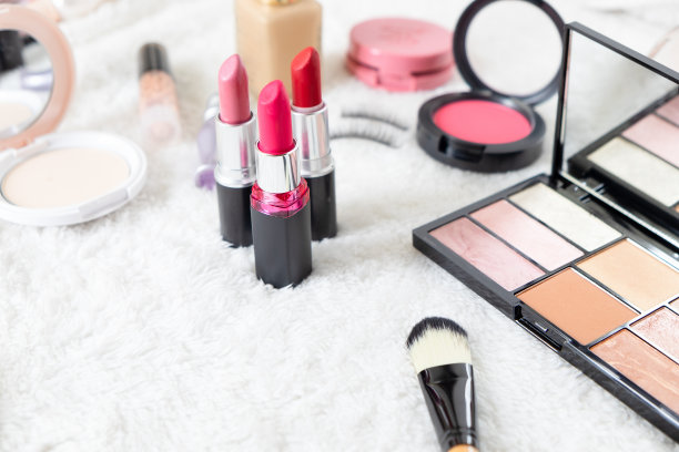 美容化妆品和各种化妆配件在白色的毛皮背景与复制空间为您的文本。美容的概念。图片下载