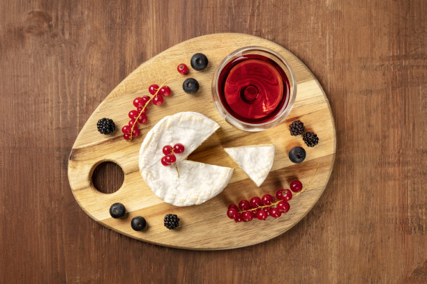 这是一张卡芒贝尔奶酪和一杯红酒和水果的头顶照片，背景是黑暗的乡村，还有一个地方可以写文章图片下载