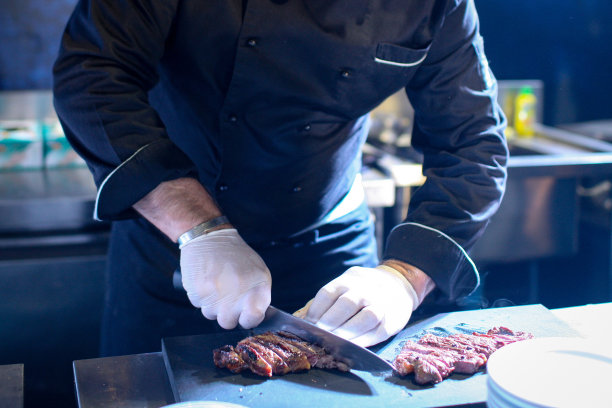 厨师用刀切美味的烤牛排图片下载