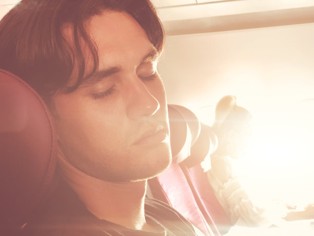 疲倦的人睡在飞机座位上。图片下载