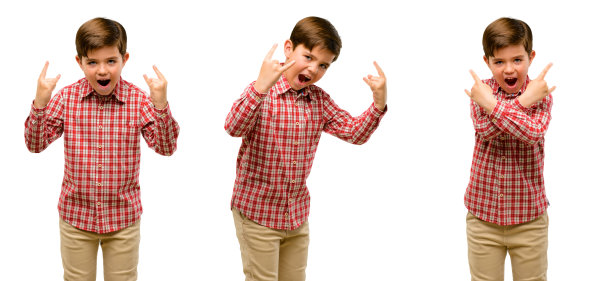 英俊的蹒跚学步的孩子与绿色的眼睛，使双手岩石象征，呼喊和庆祝图片下载