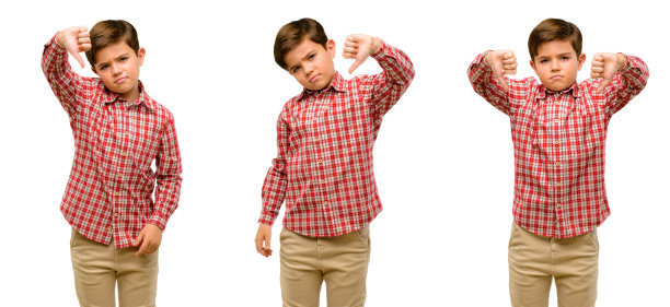 英俊的蹒跚学步的孩子有着绿色的眼睛，显示拇指向下的不愉快的迹象，表示不喜欢，消极的表达和不赞成图片下载