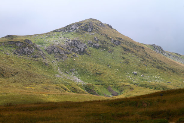 美丽的山坡自然景观照片与绿色草地在蓝天背景图片下载