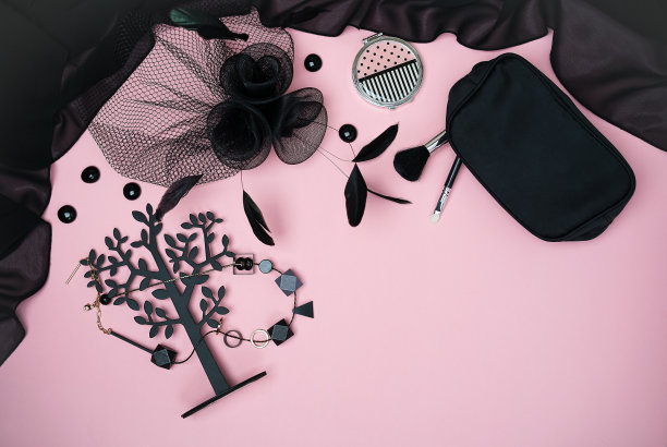 万圣节派对系列女装配饰黑色上淡粉色背景:珠宝，帽子与面纱和羽毛，化妆。平铺，俯视图，拷贝空间。“黑色星期五”的概念图片下载