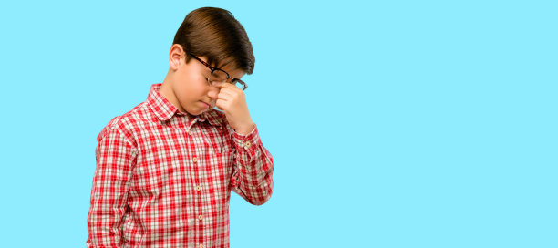 英俊的学步儿童，绿眼睛，困倦的表情，过度劳累和疲惫，因为疲倦而揉鼻子图片下载