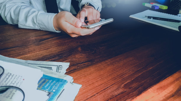 商人的手握触摸手机与空白的拷贝空间为您的短信在咖啡馆与灯光日落，复古的色调。有选择性的重点图片下载