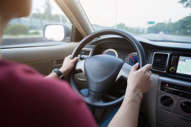 在城市道路上开车上下班的妇女图片下载