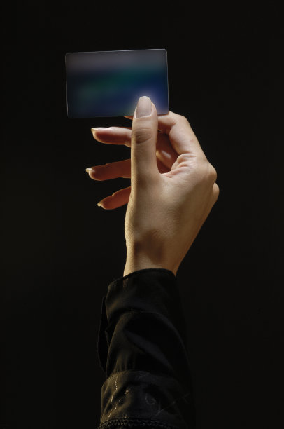 女人手持信用卡，顶部光照图片下载