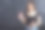 快乐女孩的肖像与油炸圈饼在黑色的背景。快乐的女孩拿着新鲜的甜甜圈微笑着。好心情，饮食观念。图片下载