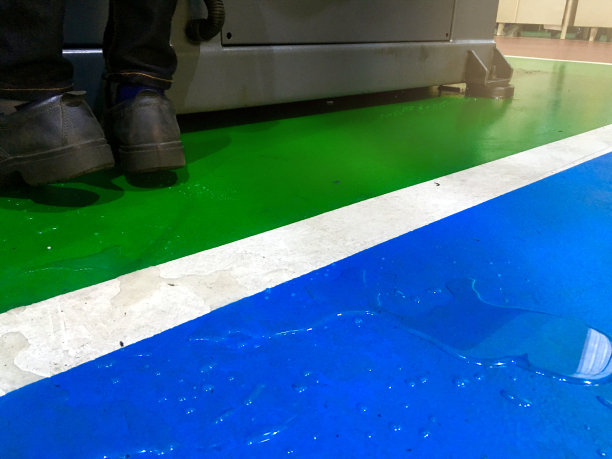 混凝土地面有油水泄漏或溢出，工作区域小心危险和事故。图片下载