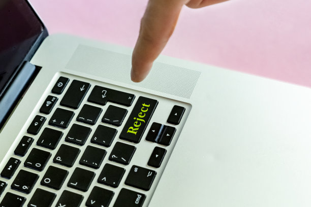靠近的人的手手指推动“拒绝”文本上的一个按钮的笔记本电脑键盘隔离概念v图片下载