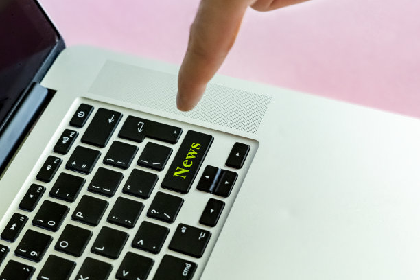 靠近的人的手手指推动“新闻”文本上的一个按钮的笔记本电脑键盘隔离概念v图片下载