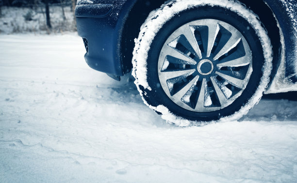 汽车轮胎在被雪覆盖的冬季道路上行驶图片下载