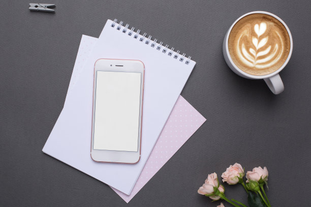手机与空白屏幕纸，闹钟和花在灰色背景在复古风格图片下载