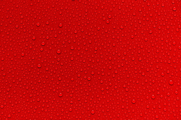 红色背景上的水滴。图片下载