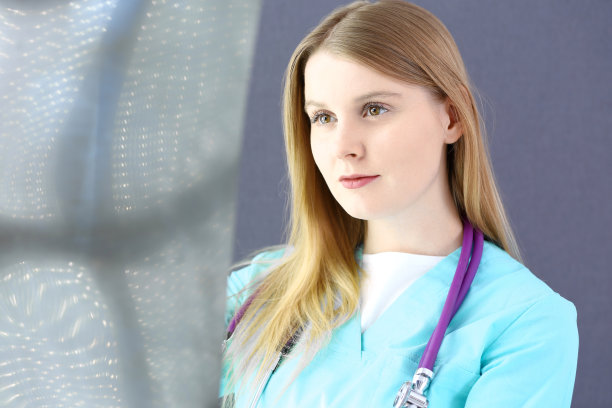 在诊所或医院，女医生站在窗边检查x光照片。医疗保健理念。医生在工作中。图片下载