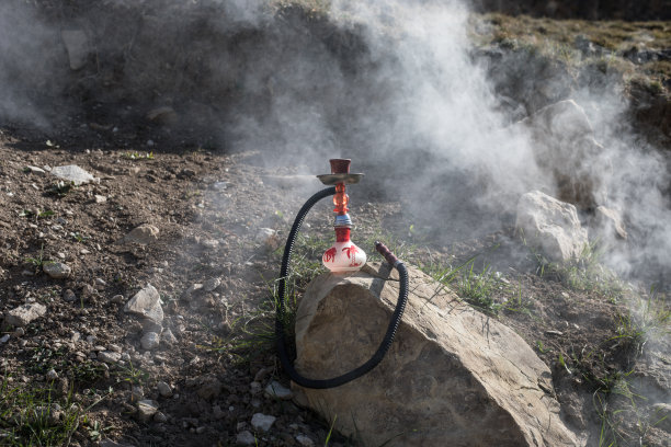 水烟，传统阿拉伯水管，直接日落光，户外照片。山的背景或水烟的剪影在日落的背景。户外。有选择性的重点图片下载