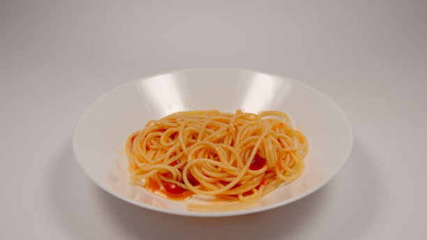 白色的桌子上放着番茄酱意大利面图片下载