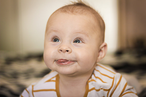 一个表情丰富的快乐婴儿的肖像，抬起头。婴儿发展概念照片，生活方式图片下载