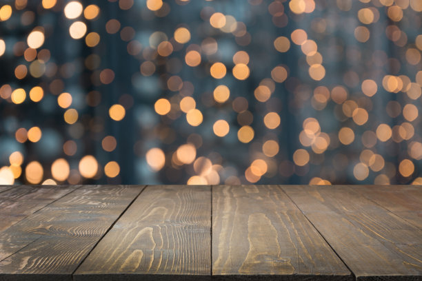模糊的金色花环和木制桌面前景。图片展示或蒙太奇您的圣诞产品。图片下载