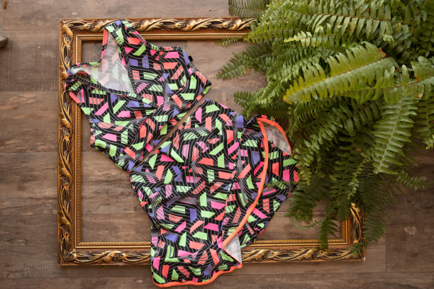 健身女子的衣服，绿色的棕榈叶排列在木制的背景上。暑假度假概念。图片下载