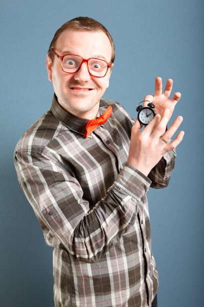 滑稽的书呆子戴着眼镜拿着小钟图片下载