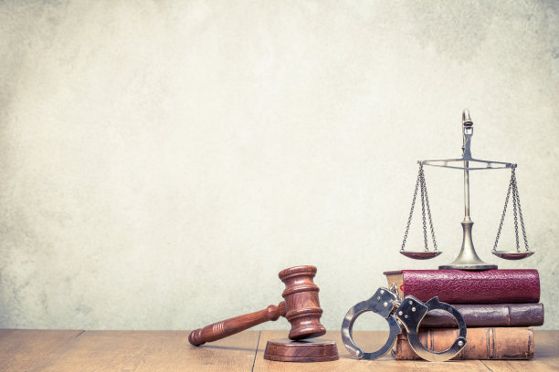木槌、复古法律天平和手铐，以及混凝土墙前的书籍。正义的象征静物。复古旧风格滤镜照片图片下载