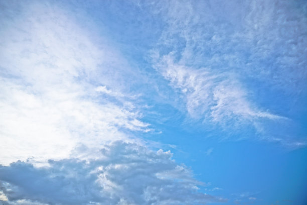 美丽的白色和灰色的云映衬着蓝色的天空。夏秋之日，从飞机上望向大气。设计素材照片图片下载