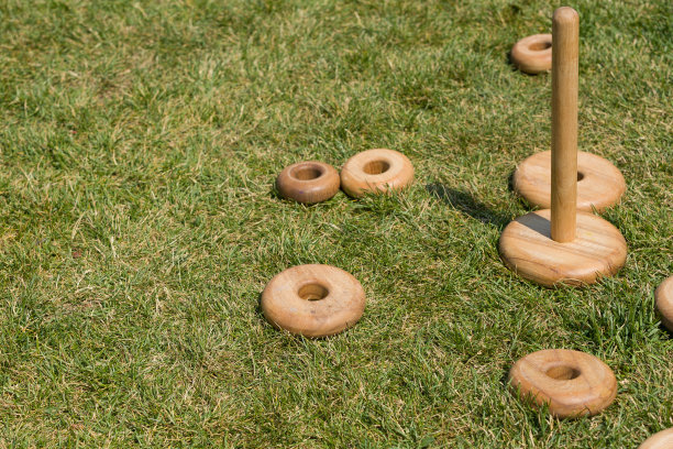 部分大木制玩具金字塔在绿色的草地上户外。图片下载