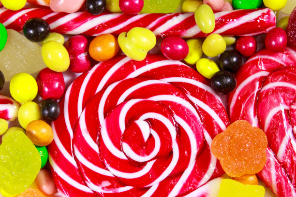 背景彩色巧克力糖果，棒棒糖，拐杖糖和果冻糖果图片下载