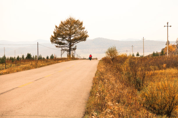 一辆摩托车正行驶在中国北方的乡村公路上图片下载