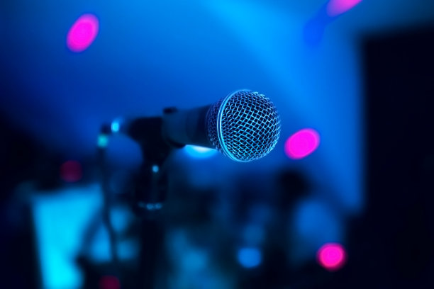 在夜总会的舞台上有一个麦克风。明亮的俱乐部灯光照在MIC上。在夜总会的演出图片下载