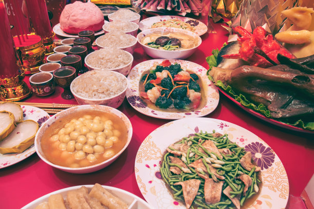 中国新年聚会餐桌红色和金色的主题食物和传统装饰。图片下载