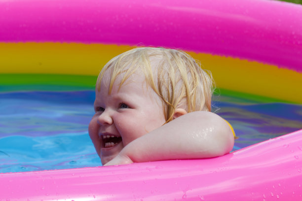 快乐的小女孩在充气泳池里洗澡图片下载