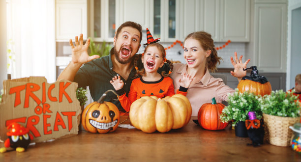 万圣节快乐!家庭妈妈，爸爸和孩子女儿切南瓜回家度假图片下载