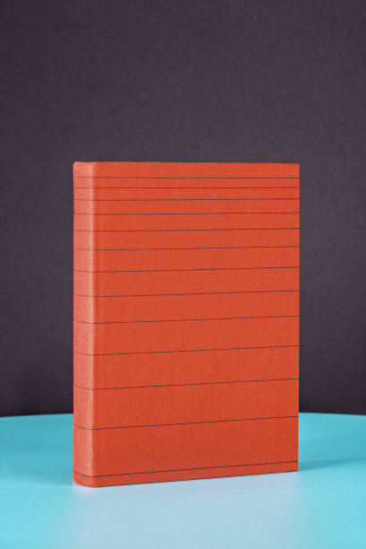 红色条纹的书放在绿色的金属桌子上。图片下载