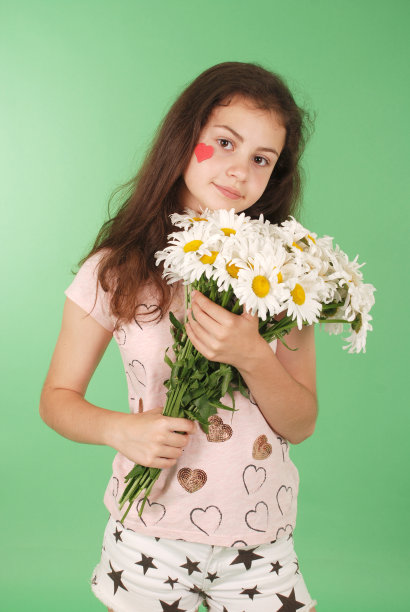 一个年轻女孩拿着一束甘菊的肖像。图片下载