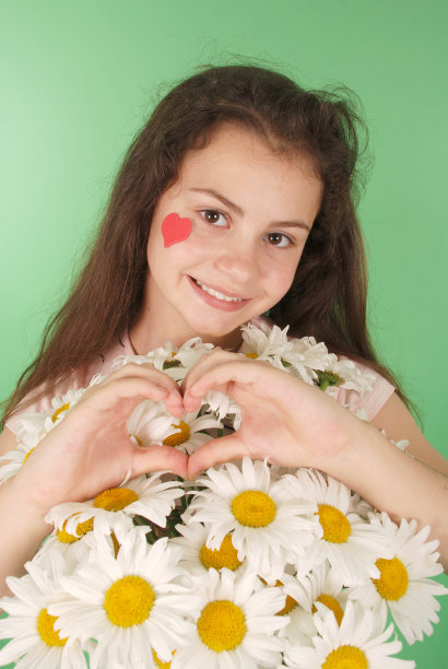 一个年轻女孩拿着一束甘菊的肖像。图片下载