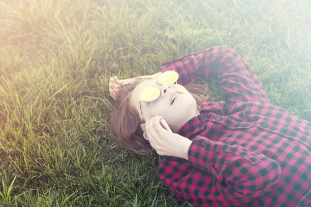 年轻漂亮的女人喜欢在新鲜的草地上聊天图片下载