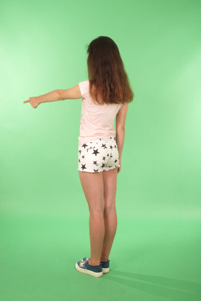 侧视图小女孩举起手望着墙。图片下载