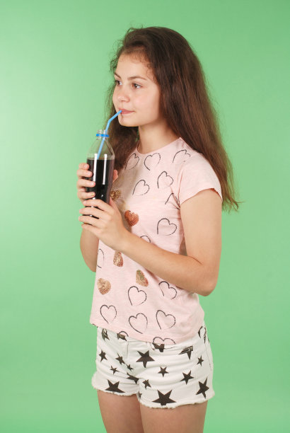 漂亮的年轻女孩手里拿着一瓶可乐图片下载