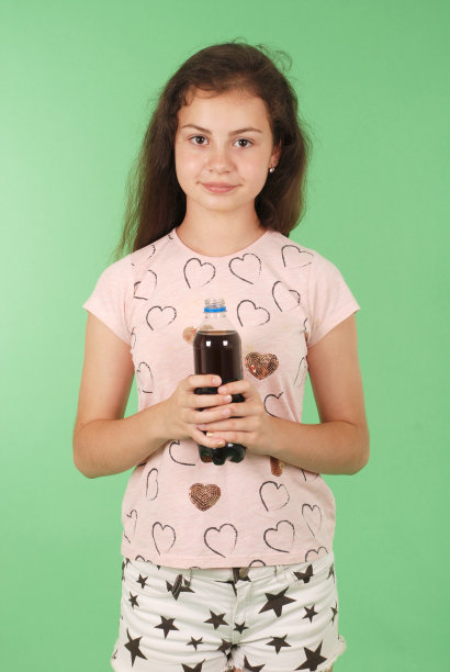 漂亮的年轻女孩手里拿着一瓶可乐图片下载