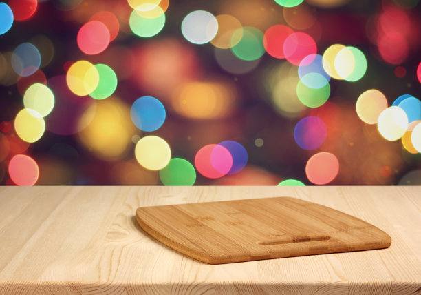 模糊的节日背景上带有砧板的木桌。圣诞节的背景。图片下载