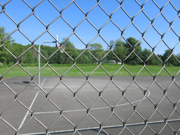 透过金属公园围栏看到的篮球场图片下载