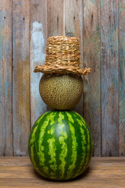 西瓜、西瓜和草帽铺在木桌上图片下载