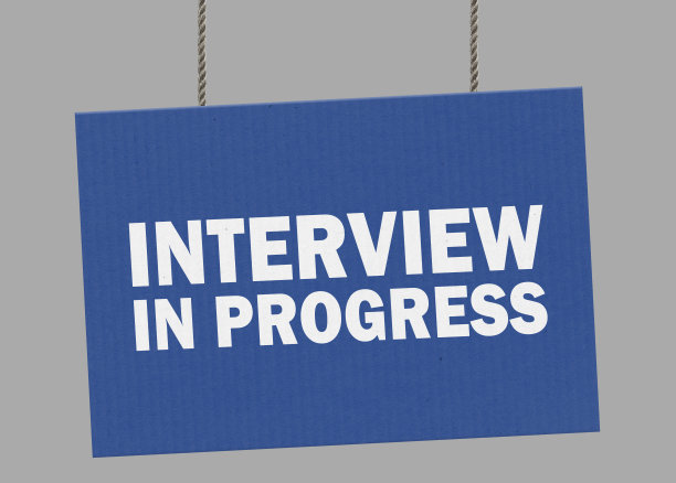 正在进行面试的纸板标牌挂在绳子上。包括剪切路径，以便您可以放置自己的背景。图片下载