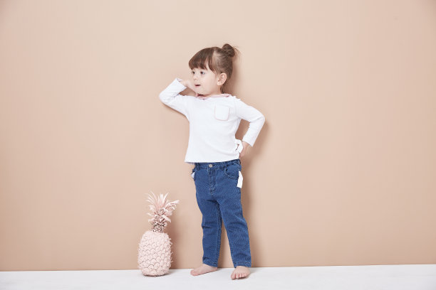 一个活泼开朗的女孩，穿着牛仔裤和白色，笑得很天真。图片下载