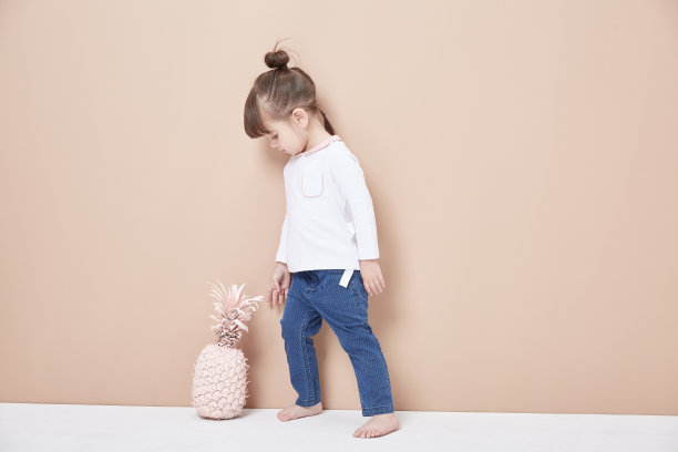 一个活泼开朗的女孩，穿着牛仔裤和白色，笑得很天真。图片下载