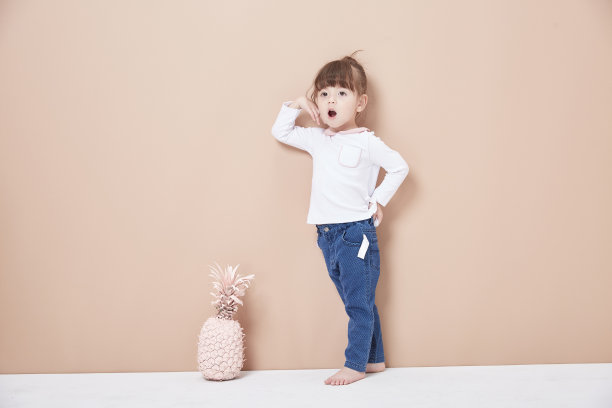 一个活泼开朗的女孩，穿着牛仔裤和白色，笑得很天真。图片下载