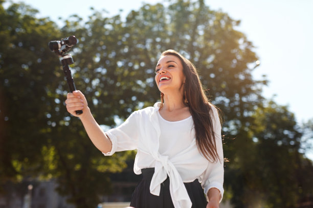 一名女子在街上用相机记录视频博客素材图片